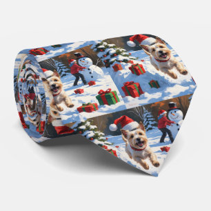 Cairn Terrier läuft im Schnee mit Weihnachtsmütze Krawatte