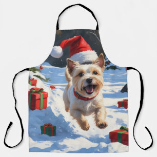 Cairn Terrier läuft im Schnee mit Weihnachtsmütze Schürze