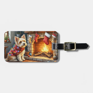 Cairn Terrier sitzt vor dem Kamin mit Weihnachtsbe Gepäckanhänger