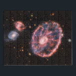 Cartwheel Galaxy, James Webb Space Telescope Puzzle<br><div class="desc">Schauen Sie durch das kosmische Schlüsselloch und sehen Sie die Cartwheel Galaxy, ein himmlisches Spektakel anders als jedes andere. Das Webb Teleskop enthüllt seine majestätische Form, einen Ring von brillantem Sternlicht, der einen verzerrten Kern umgibt, ein Zeugnis für einen kolossalen Zusammenstoß mit einer kleineren Galaxie vor langer Zeit. Geflankt von...</div>