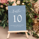 Chic Script Dusty Blue Wedding Reception Tischnummer<br><div class="desc">Chic dusty blue Hochzeitsempfang mit "table" in einem modernen, weißen Drehbuch mit Swashes, der Tischnummer in der eleganten weißen Serif-Typografie, Ihren Vornamen verbunden mit einem Herz und Ihrem Empfang Datum. Erstellen Sie jede Tischnummer einzeln und fügen Sie sie einzeln zu Ihrem Warenkorb hinzu, dann Karo aus, sobald alle Zahlen in...</div>