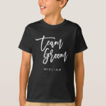 Chic Trendy Brush White Script Team Groom T-Shirt<br><div class="desc">T - Shirt mit den Worten "Team Groom" in einem schicken, trendigen Pinsel weißen Skript, das perfekt für den Ringträger ist. Weitere passende Elemente finden Sie hier https://www.zazzle.com/collections/119250194970828530?rf=238364477188679314 Personalisieren Sie es, indem Sie den Platzhalter-Text ersetzen. Für weitere Optionen, wie zum Beispiel den Schriftart zu ändern und seine Größe, Farbe oder...</div>