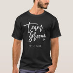 Chic Trendy Brush White Script Team Groom T-Shirt<br><div class="desc">T - Shirt mit den Worten "Team Groom" in einem schicken, trendigen Pinsel weißen Skript, das perfekt für Trauzeuge und Trauzeuge ist. Weitere passende Elemente finden Sie hier https://www.zazzle.com/collections/119250194970828530?rf=238364477188679314 Personalisieren Sie es, indem Sie den Platzhalter-Text ersetzen. Für weitere Optionen, wie zum Beispiel den Schriftart zu ändern und seine Größe, Farbe...</div>