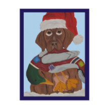 Chocolate-Labrador-Welpe in Santa-Mütze mit Enten-