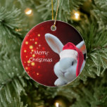 Christmas Santa Bunny Keramik Ornament<br><div class="desc">Das kleine flauschige Hasen ist auf einem roten Weihnachtshintergrund mit einer Weihnachtsmannmütze und wünscht Ihnen ein frohes Weihnachtsfest.</div>