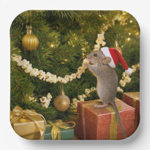 Christmausmaus, der Popcorn-Girlande am Baum isst Pappteller