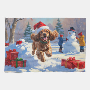 Cocker Spaniel läuft im Schnee mit Weihnachtsmütze Geschirrtuch