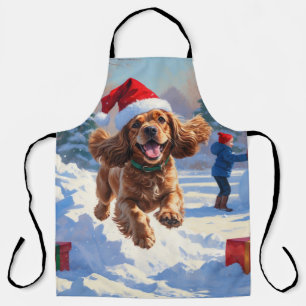 Cocker Spaniel läuft in Schnee mit Weihnachtshut Schürze