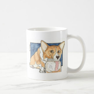 Corgi, der das Erdnussbutter-Glas leckt Tasse