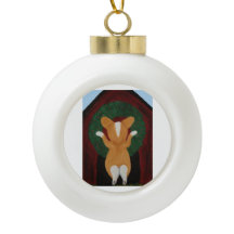 Corgi hängt Weihnachtskranz an das Hundehaus