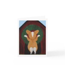 Corgi hängt Weihnachtskränze an das Hundehaus