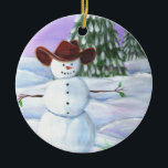 Cowboy Snowman Keramikornament<br><div class="desc">Cowboy Snowman illustriertes Bild. Er trägt einen braunen Cowboyhut,  sitzt in Schneerollen mit Kiefern und lila Sonnenuntergang im Hintergrund.</div>