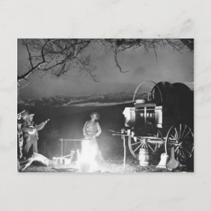 Cowboys singen und spielen um ein Lagerfeuer herum Postkarte