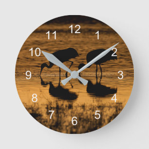 Cranes Silhouette vom Sonnenuntergang Runde Wanduhr