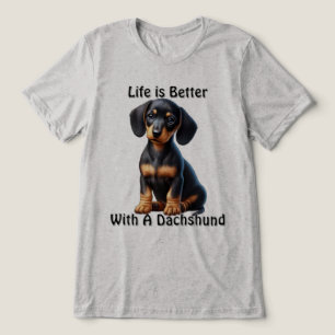Dachshund-Welpe sitzt und schaut mit unschuldigem Tri-Blend Shirt