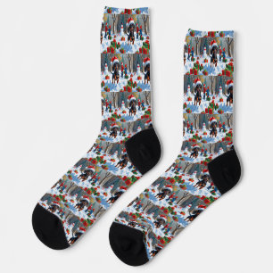 Dackel läuft im Schnee mit Weihnachtsmütze Socken