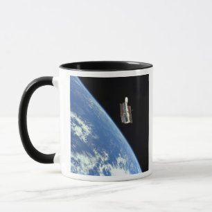 Das Hubble Weltraumteleskop mit einer blauen Erde Tasse