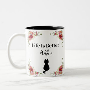 Das Leben ist besser, wenn die Katzenblüte in der Zweifarbige Tasse