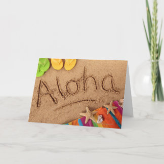 Das Wort Aloha geschrieben auf einem Sandstrand, m Karte