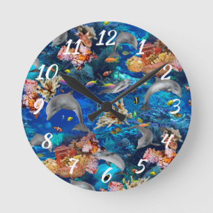 Delphine im Ozean schwimmen um das Korallenriff Runde Wanduhr