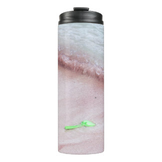 Der Fuß der Person neben der grünen Schaufel am Me Thermosbecher
