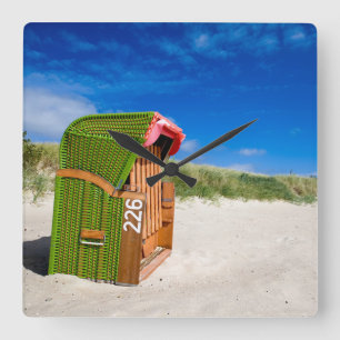 Der grüne Strandstuhl in der Nordsee Quadratische Wanduhr