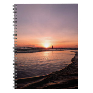 Der Sonnenuntergang am Strand ist dunkel, hell und Notizblock