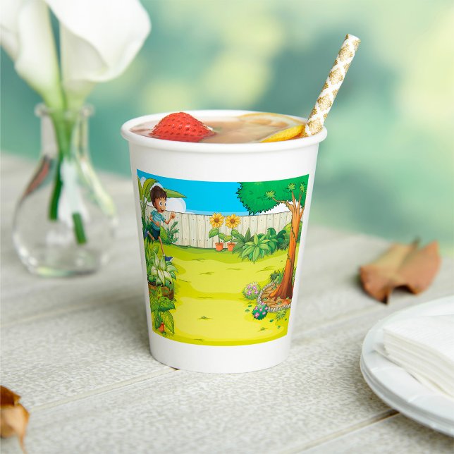 Der spielerische Junge, der in einem üppig grünen  Pappbecher (Von Creator hochgeladen)