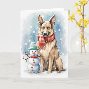 Deutscher Schäferhund mit Weihnachtsmütze neben ei Karte