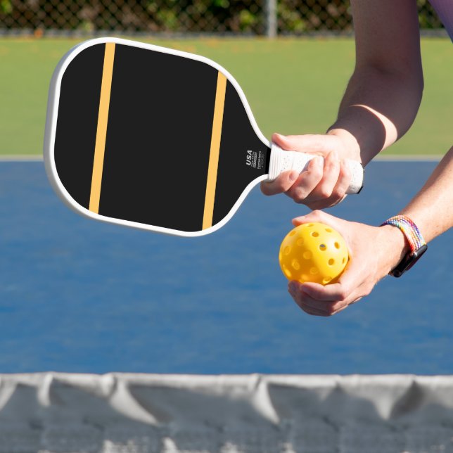 Dicke goldene Streifen glänzen schwarzer Hintergru Pickleball Schläger (InSitu)