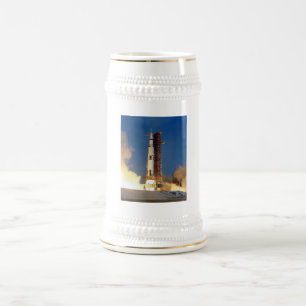 Die Erde bebt, während Saturn V zum Mond aufsteigt Bierglas
