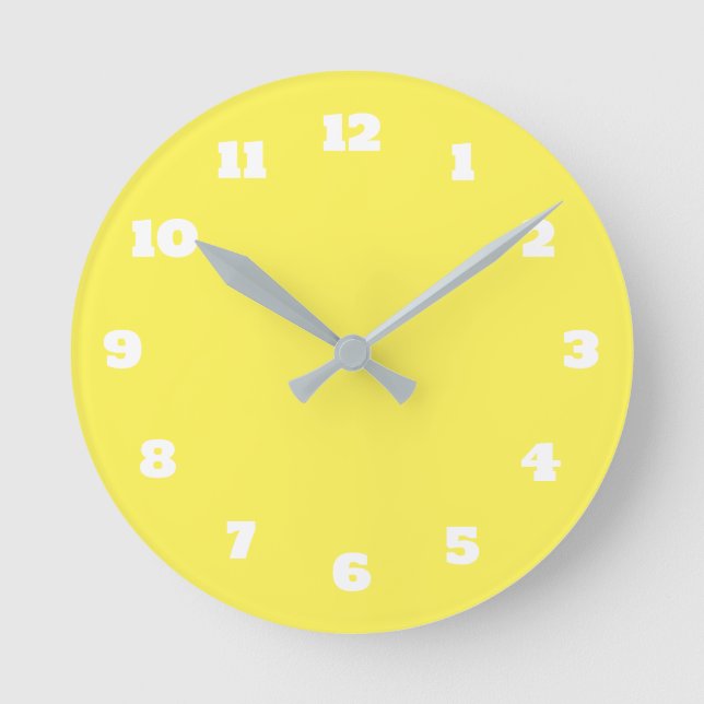Die Farbe Gelb und Weiß ist hell. Runde Wanduhr (Vorderseite)