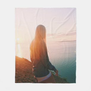 Die Frau steht während der goldenen Stunde in der  Fleecedecke