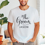 Die Groom Black Script Personalisierte Hochzeit T-Shirt<br><div class="desc">Das Wedding Groom Shirt verfügt über moderne,  schwarz wirbelnde Kalligraphie-Skripte mit elegantem Vornamen,  den Sie personalisieren können. Sehen Sie sich unsere koordinierenden Brautparty-Designs an!</div>