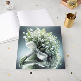 Die Hochzeitslilie des Tales Bouquet auf einem Spi Gästebuch