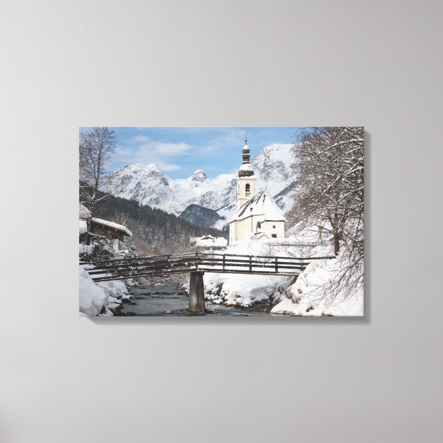 Die Kirche im Schnee mit den Alpen im Winter Leinwanddruck (Vorderseite)