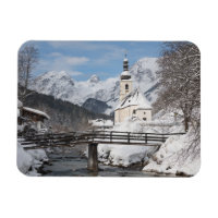 Die Kirche im Schnee mit den Alpen im Winter