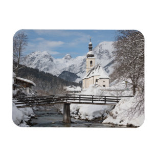 Die Kirche im Schnee mit den Alpen im Winter Magnet