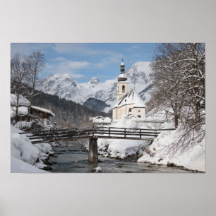 Die Kirche im Schnee mit den Alpen im Winter Poster