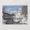 Die Kirche im Schnee mit den Alpen im Winter