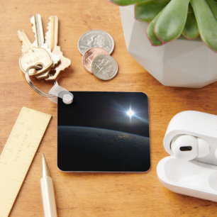 Die Sonne liegt über dem Horizont der Erde. Schlüsselanhänger