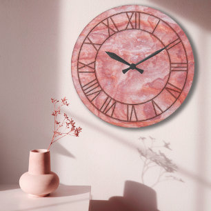 Die Uhr an der Wand aus rosa Marmor