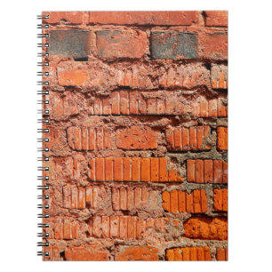 Die Wand aus rotem Ziegelstein ist veraltet, alt, Notizblock