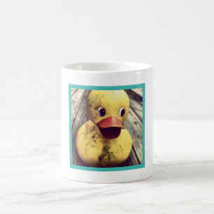 Dirty Rubber Duck sitzend auf einem Holzdeck Kaffeetasse