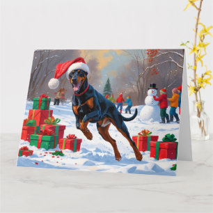 Doberman läuft im Schnee mit Weihnachtshut Karte
