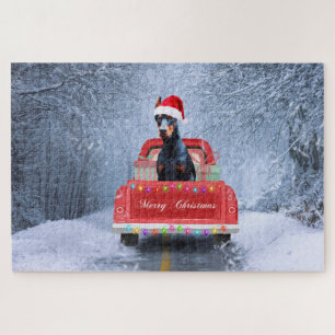 Dobermann-Hund im Schnee sitzt im Weihnachts-LKW Puzzle