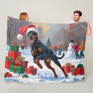 Dobermann läuft im Schnee mit Weihnachtsmütze Fleecedecke