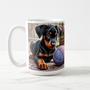 Dobermann-Welpe mit Wollball auf einem farbenfrohe Kaffeetasse