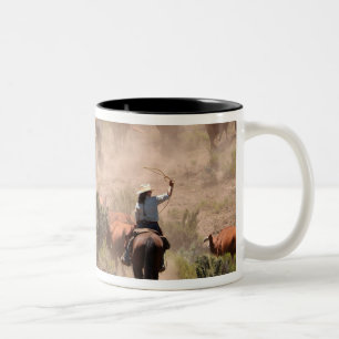 Drei Cowboys und Cowgirls treiben Rinder Zweifarbige Tasse