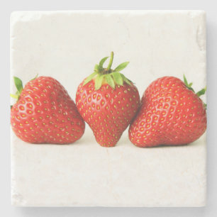 Drei Erdbeeren an der weißen Küste Steinuntersetzer
